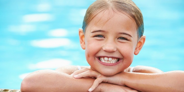 Young Girl Resting On The Edge Of Swimming Pool
