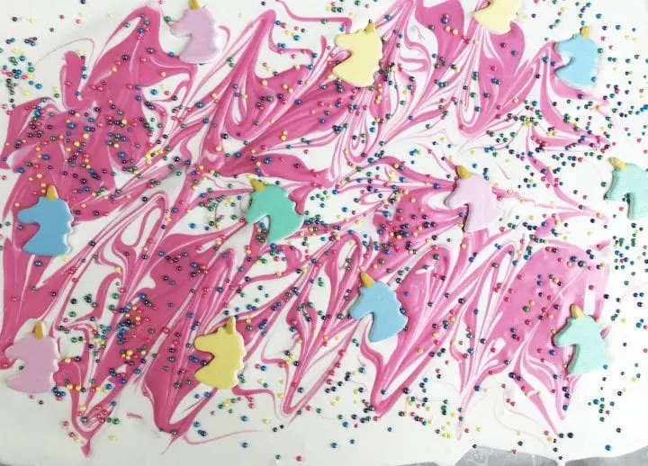 Pink and white swirled candy topped with sprinkles and unicorn heads. 
