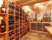 Bright home wine cellar with wooden storage units with bottles.