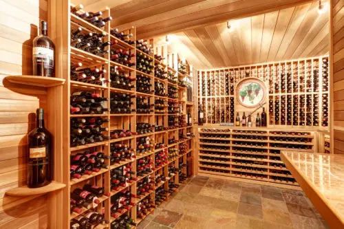 Bright home wine cellar with wooden storage units with bottles.