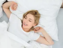Woman Stretching Arms In Bed
