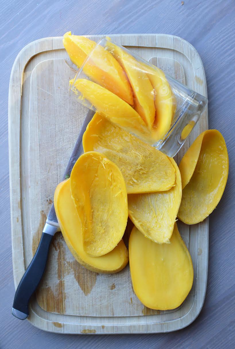 mangoes sliced on cutting board 
