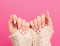 female hands with beautiful long nails with manicure with hear