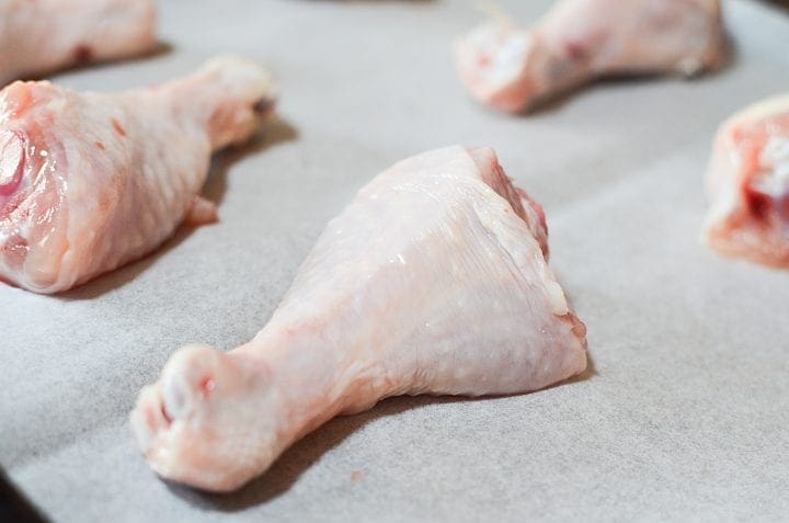 raw chicken legs with skin before baking and sauce