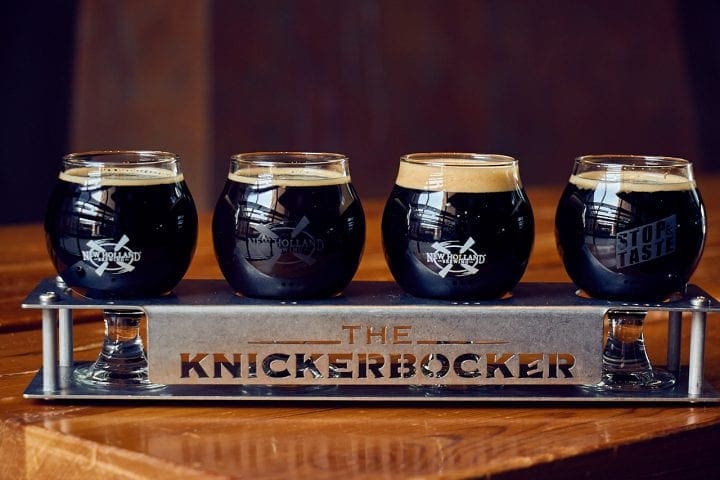 4 beer tasting glasses set in a metal tray.