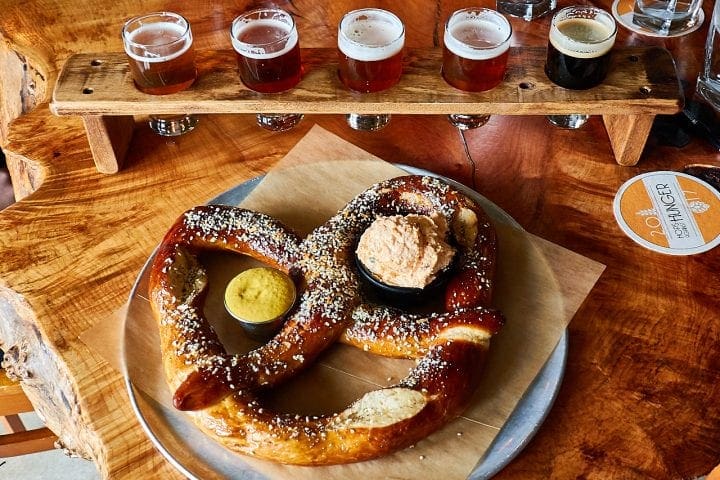 Large pretzel served with beer tasting shots.