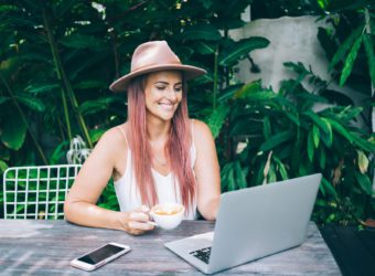 Beautiful blogger in hat working in garden