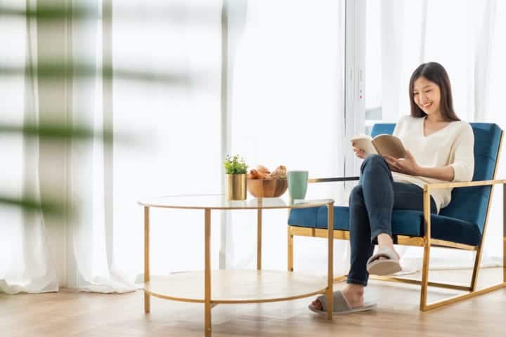 woman smiling reading a book minimalist furniture