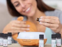 woman dripping essential oils into a diffuser