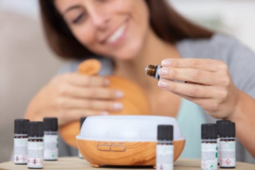 woman dripping essential oils into a diffuser