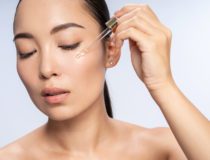 Asian beautiful female is applying eye serum