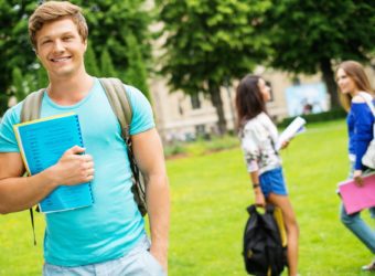 Handsome man student in a city park on summer day