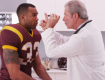 College football player having senior doctor review his concussi