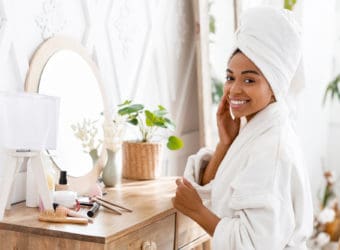 Black Woman Sitting At Toilet Table And Touching Her Perfect Skin