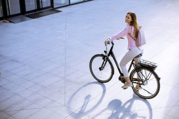 Young woman with modern city electric e bike clean sustainable u