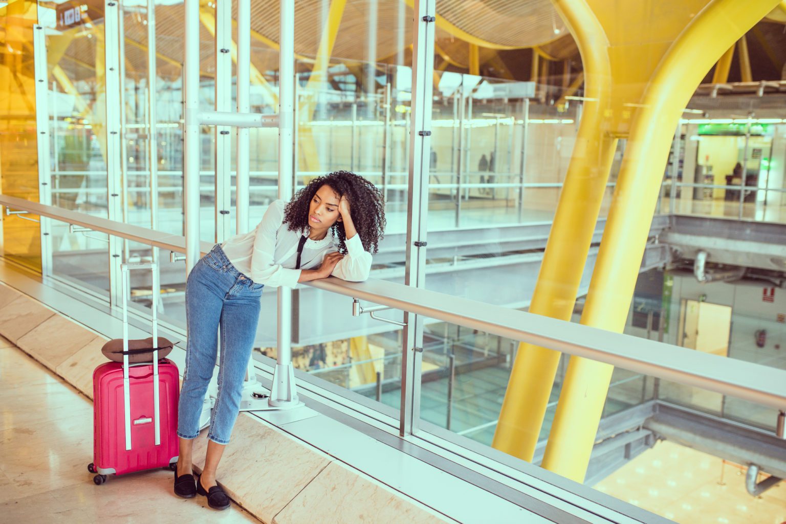 Woman sad and unhappy at the airport with flight canceled