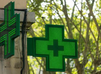 Closeup of a green pharmacy sign outside a pharmacy store in France