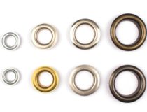 Set of brass multicoloured metal eyelets or rivets curtains rings for fastening fabric to the cornice, isolated on white with copyspace for text for your presentation