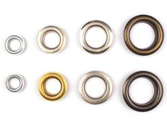 Set of brass multicoloured metal eyelets or rivets curtains rings for fastening fabric to the cornice, isolated on white with copyspace for text for your presentation