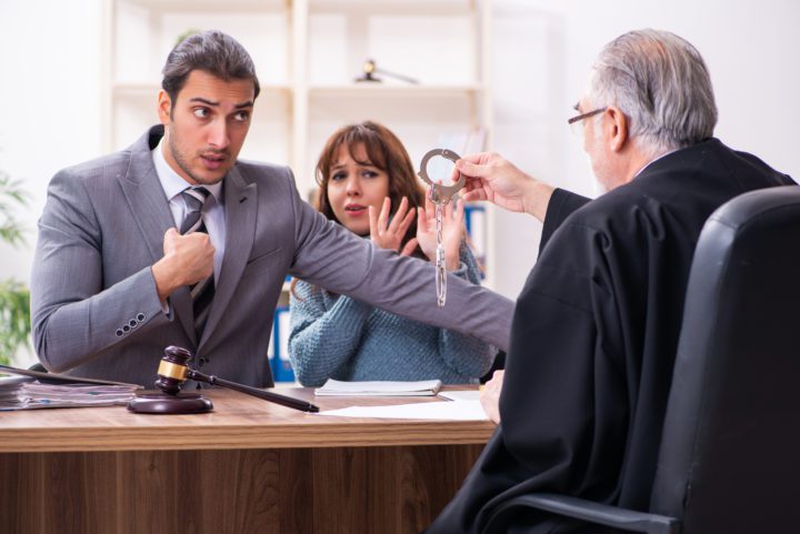 Young woman in courthouse with judge and lawyer