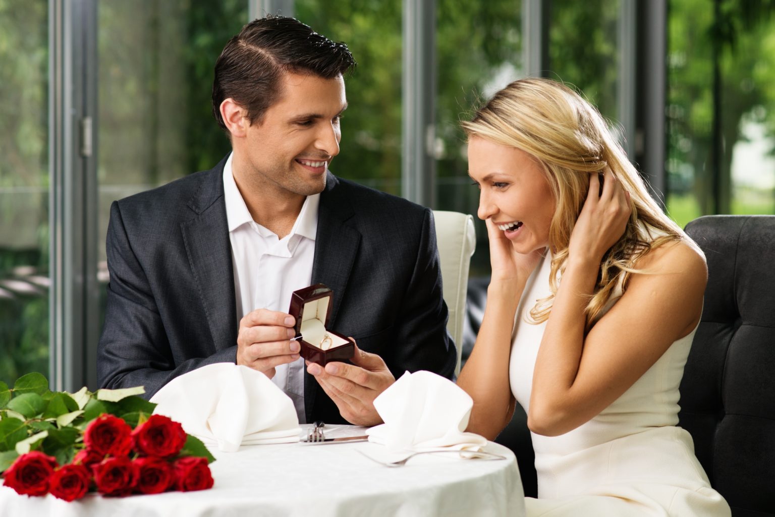 Man holding box with ring making propose to his girlfriend